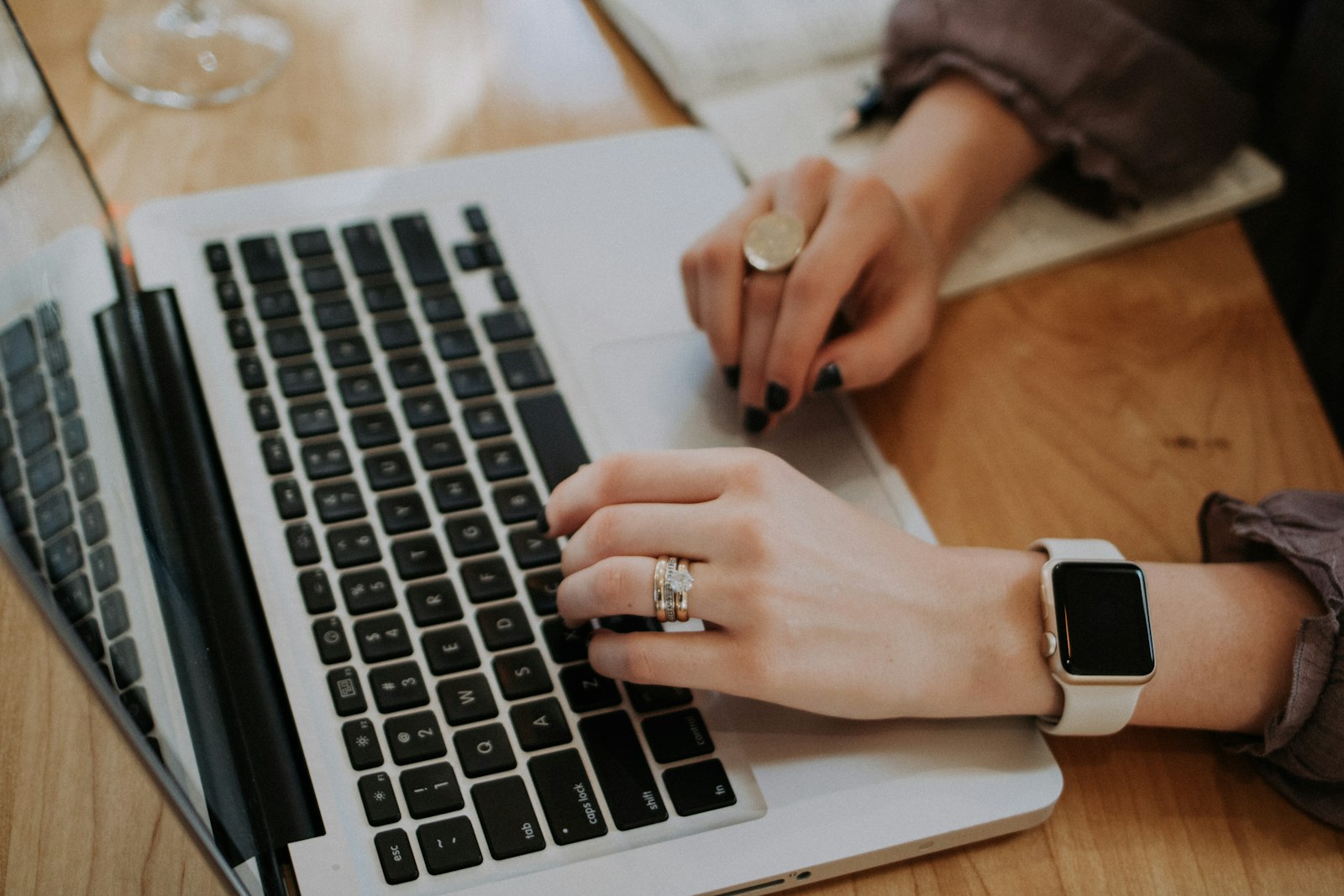 Small business owner planning at a laptop with a notebook